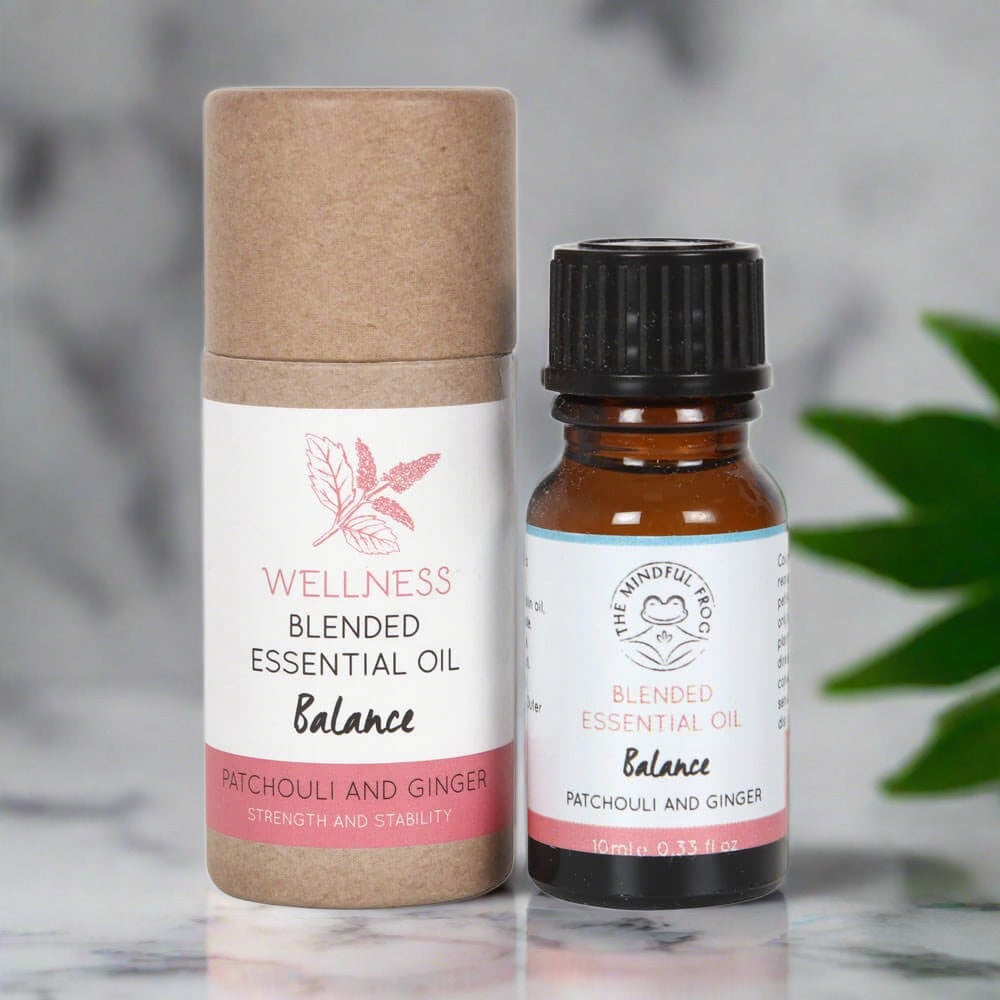 Cardboard essential oil bottle packaging, with a white and pink label, next to a 10ml brown bottle of essential oil.