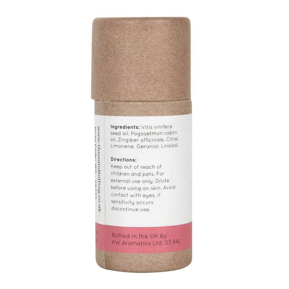 Cardboard essential oil bottle packaging, featuring a white and pink label that states ingredients.