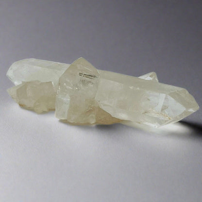 A side view of a Clear Quartz Wand that has mini Clear Quartz clusters coming off of it.