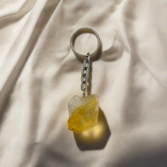 A chunk of yellow rough Citrine crystal on a silver keychain.