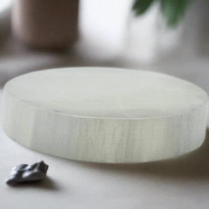 A side view of the chunky and smooth Selenite plate dish charger.