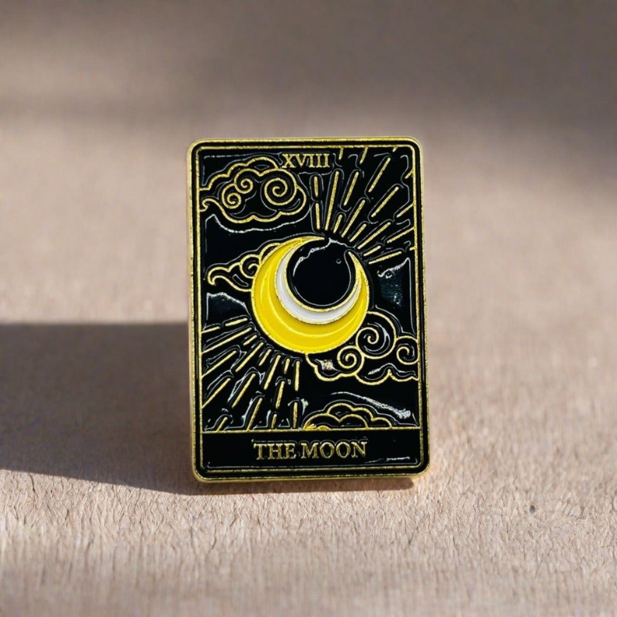 The Moon Tarot Card pin badge, with a yellow crescent moon in the middle and the words The Moon in gold at the bottom.